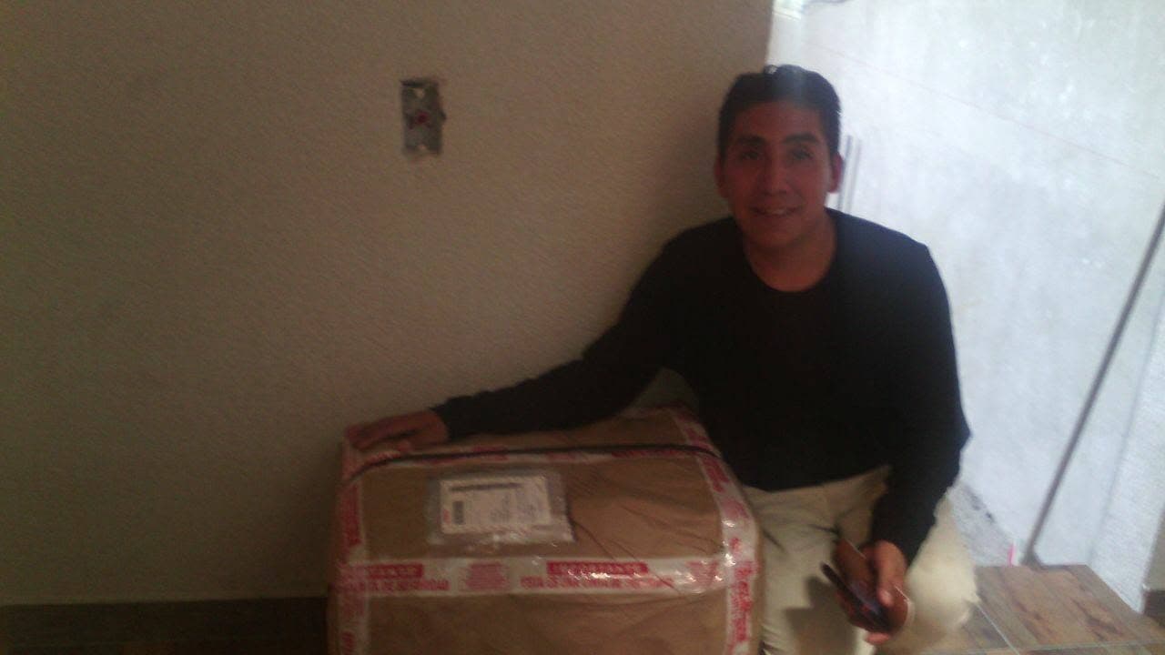 Cliente de Paquetería Colibrí con su caja lista para enviar